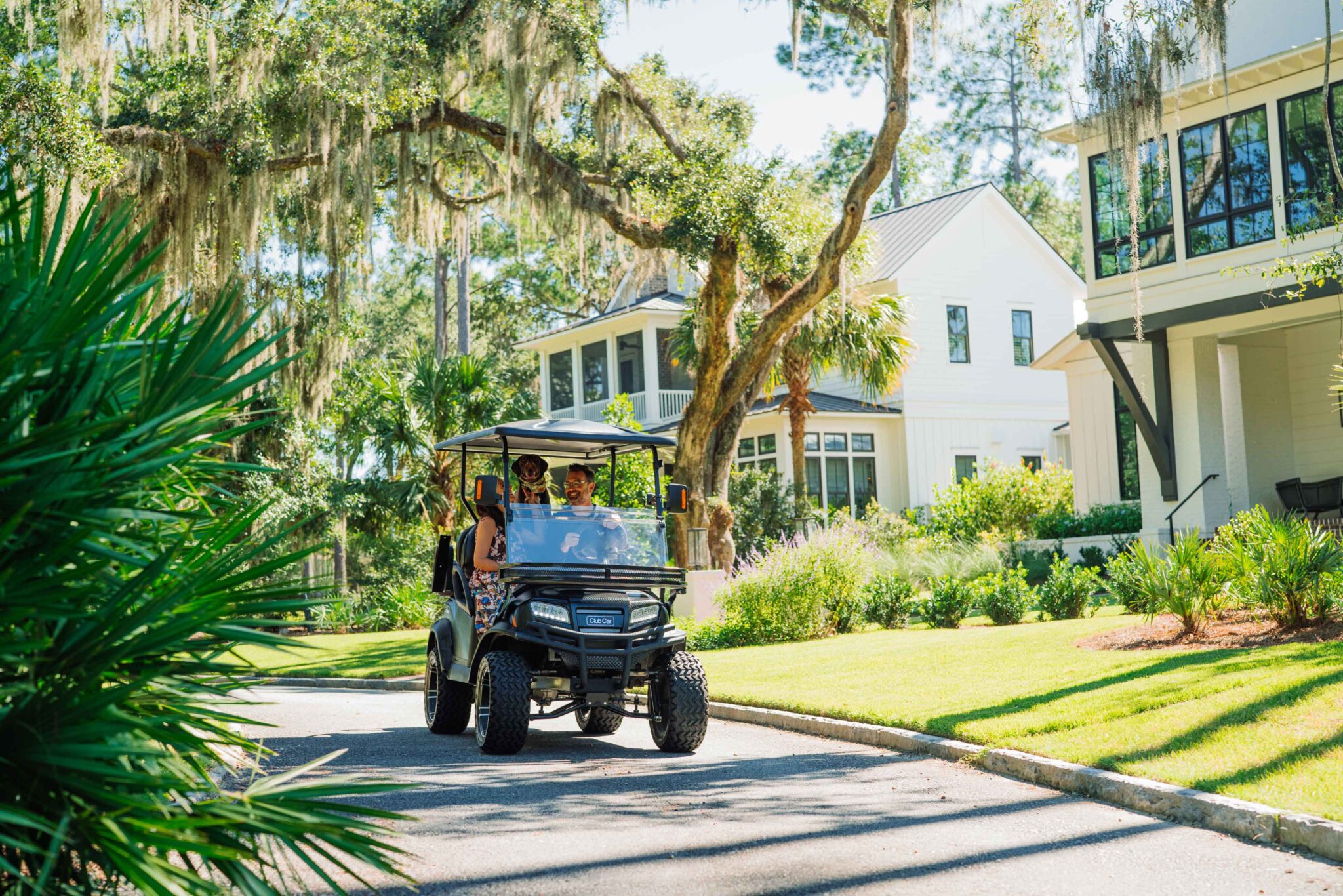 People driving a gold cart at Montage Palmetto Bluff